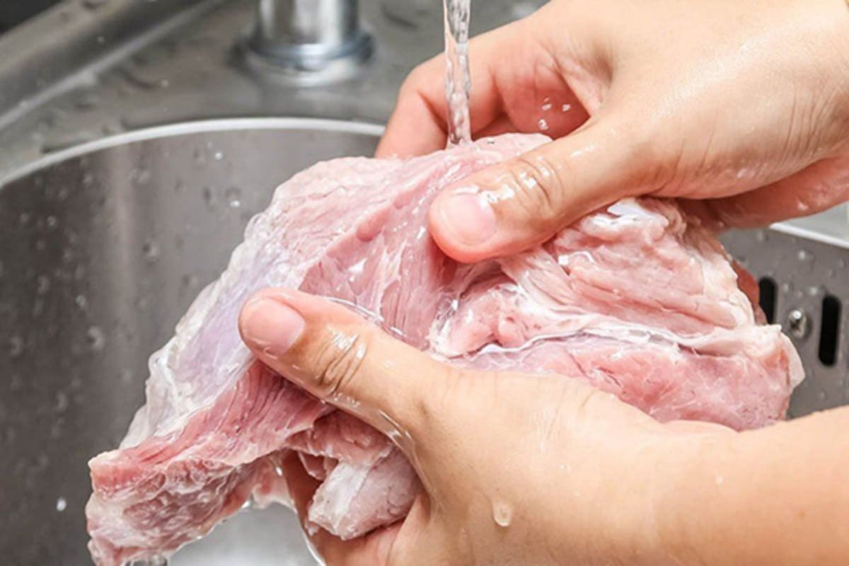 Bạn cần phải rửa sạch thịt heo với nước nhiều lần để thịt bớt hôi